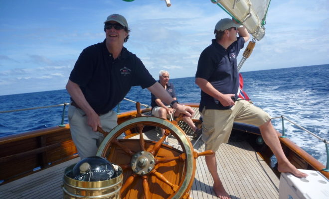 Maine Boats, Homes & Harbors Publisher John K. Hanson, Jr., at the helm of SINCERITY as owner Trygve Bratz, of Camden, looks on.
