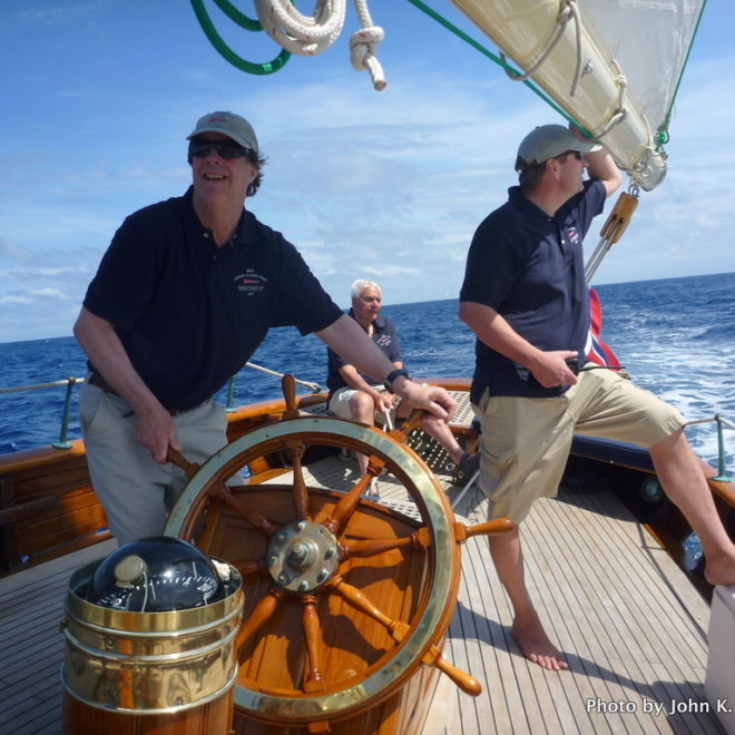 Maine Boats, Homes & Harbors Publisher John K. Hanson, Jr., at the helm of SINCERITY as owner Trygve Bratz, of Camden, looks on.
