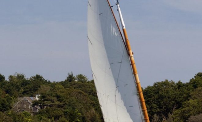 A 20' catboat tacks near the shore on Little Pleasant Bay.