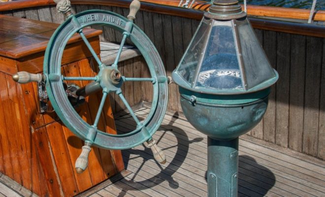 The wheel and binnacle of the schooner WHEN & IF, in Rockport for some paint and service work before the season begins.