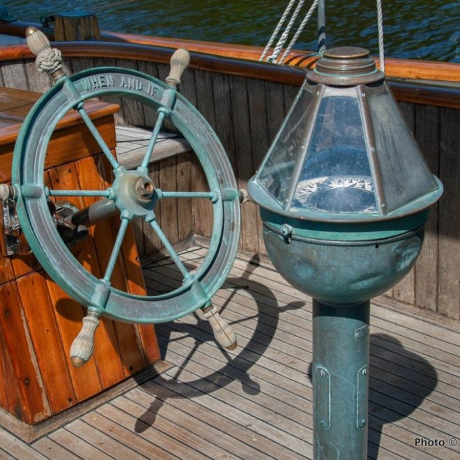 The wheel and binnacle of the schooner WHEN & IF, in Rockport for some paint and service work before the season begins.