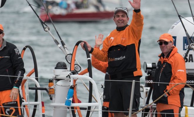 The hometown hero, Charlie Enright of Bristol, waves after taking second place in the in-port race.