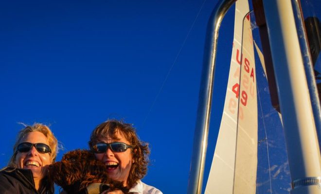 Portland Yacht Club members Ann Blanchard and Pam Thomas man the chase boat with a little canine help.