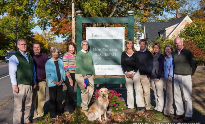 The crew of The New England Real Estate Company stands at the site of the company's new office in Camden, Maine.