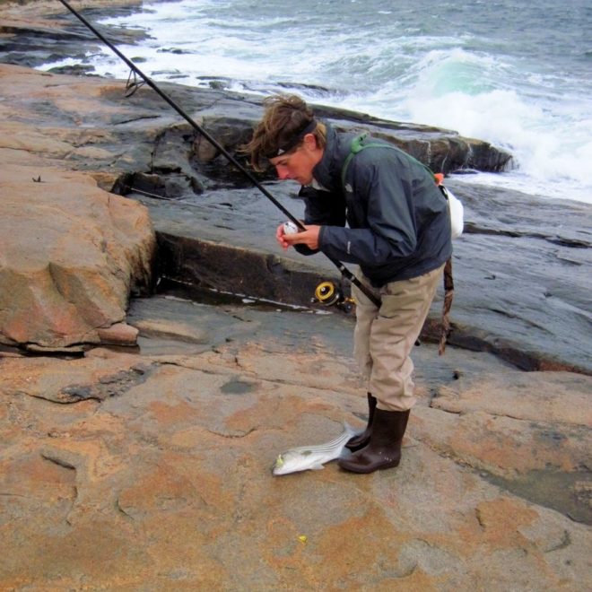 My son, Ben, lands a striper on a stormy day at the Narragansett shore.