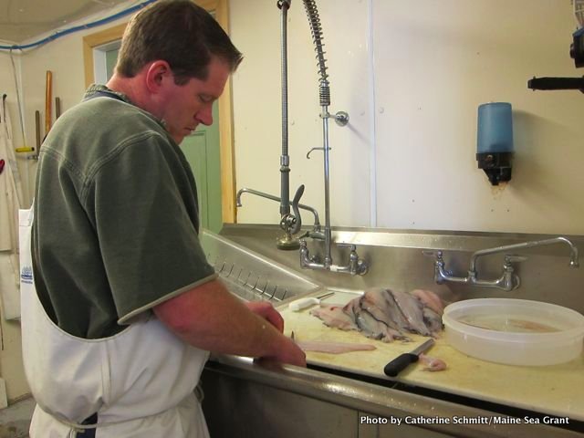 Jamie Johnson, manager at Jess's Market in Rockland, filets some fresh fish