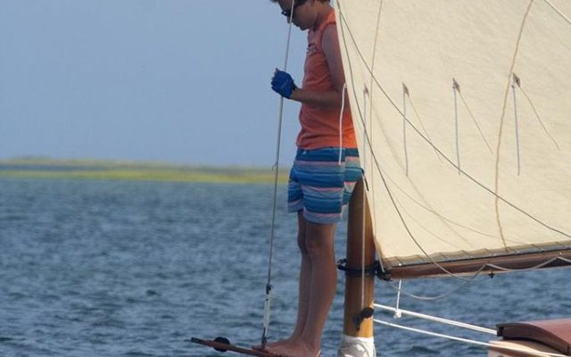 Harry, one of the 2015 Arey's Pond Boat Yard sailing instructors, watches the depth on Carl Bechgaard's 16' APBY Cabin Lynx.
