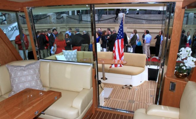 Guests attending the launch celebration at Rowes Wharf are seen through the tall rear windows of the Sabre 48.