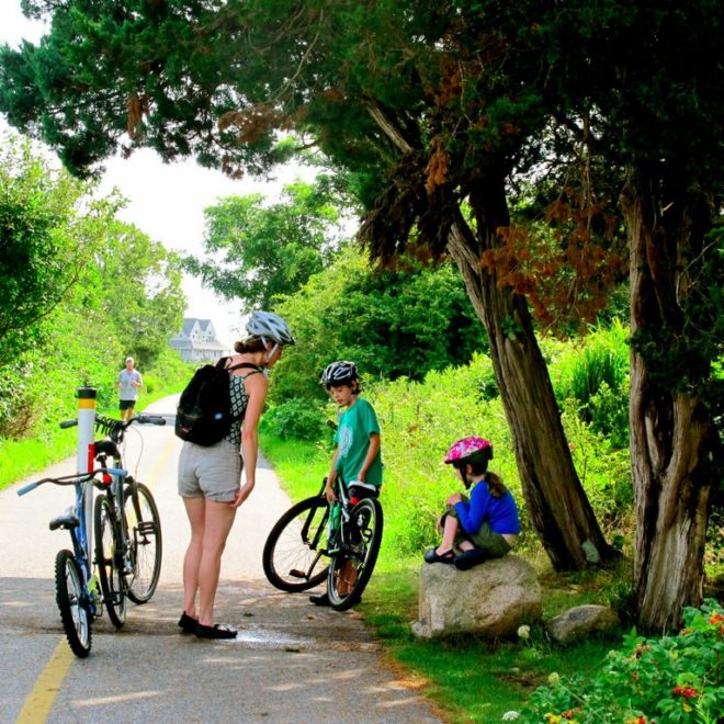 A family as they take a quick break before passing through the Surf Drive Beach section of the bike path.