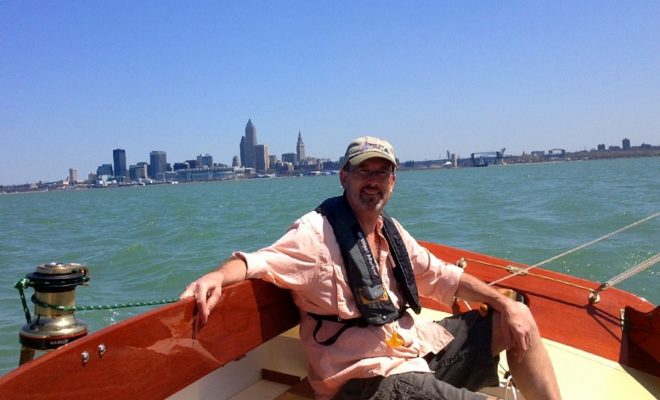 The proud new owner of BLOSSOM, a Pisces 21 built by Classic Boat Shop, at the helm on Lake Erie.