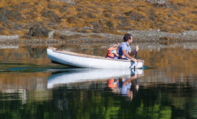 A father gets a bear hug from his tiny daughter, for taking her for a leisurely row.