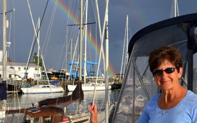 Connie Thuotte enjoys a rainbow while moored in Camden‚Äôs inner harbor during a summer cruise.