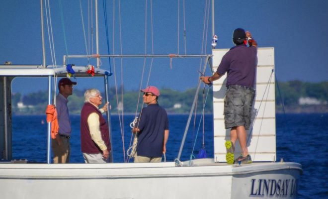 The Portland Yacht Club race committee checks the wind and sets the race course.