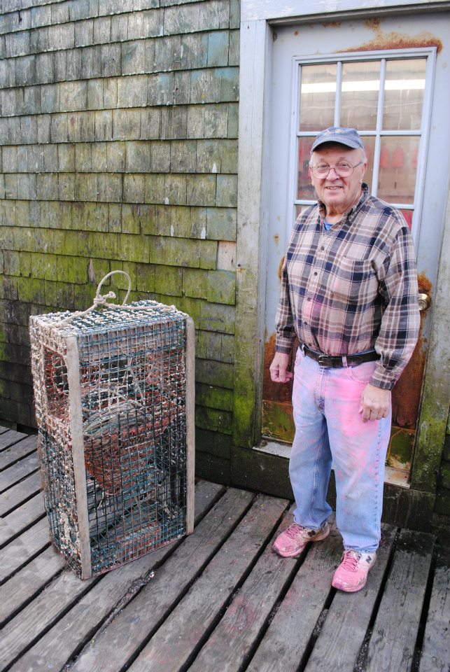 Dell, a longtime Bernard lobsterman, takes a break from painting his buoys. Photo by Alex Plummer/USHarbors.com.