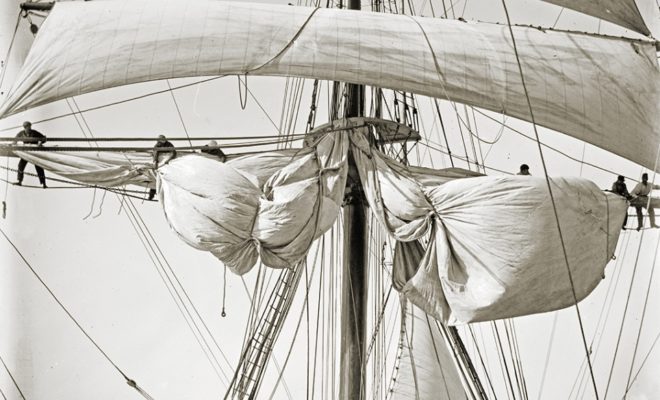 Crew taking up new topsail.