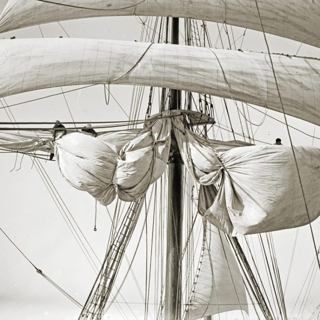 Crew taking up new topsail.