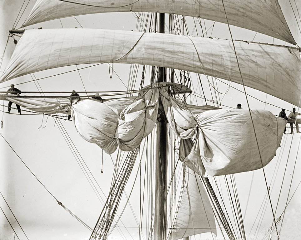 Crew taking up new topsail.
