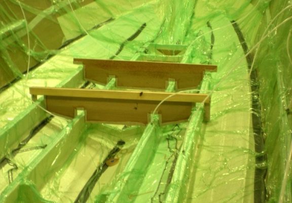 Once all core and dry fiberglass is installed, resin-distribution lines are run and a plastic sheet seals the assembly Once all core and dry fiberglass is installed, resin-distribution lines are run and a plastic sheet seals the assembly