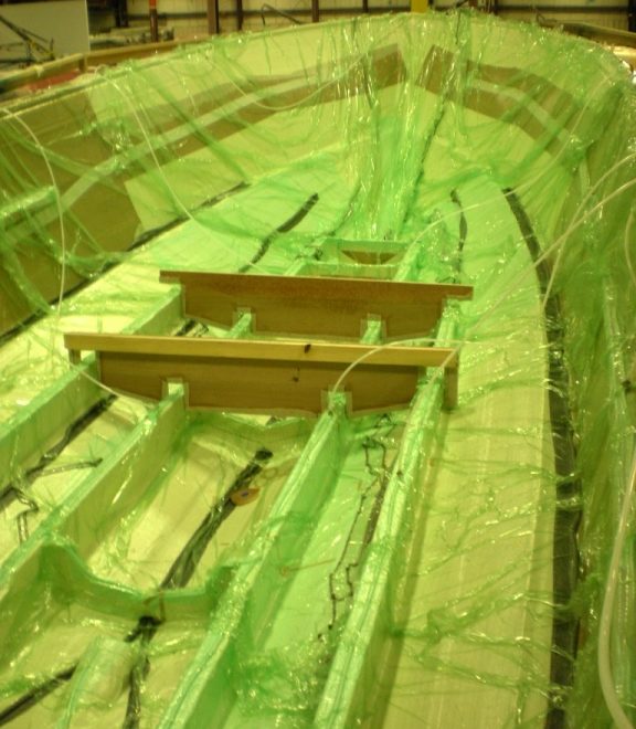 Once all core and dry fiberglass is installed, resin-distribution lines are run and a plastic sheet seals the assembly