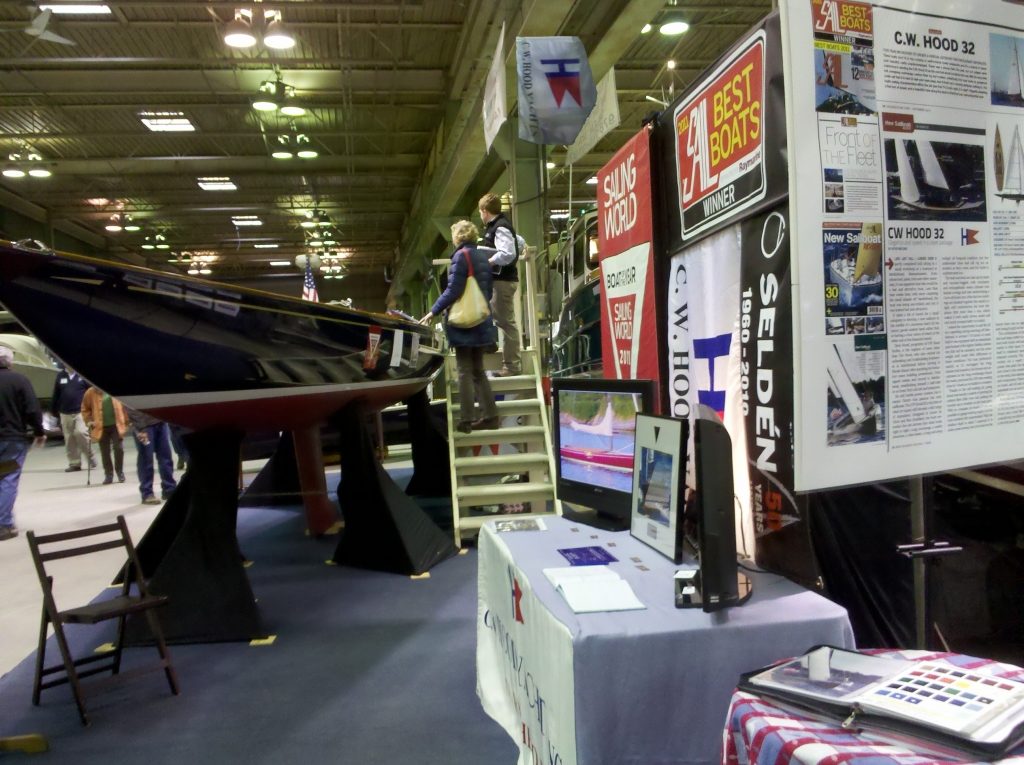 Two guests take in the CW Hood booth and a gorgeous new daysailer on display..