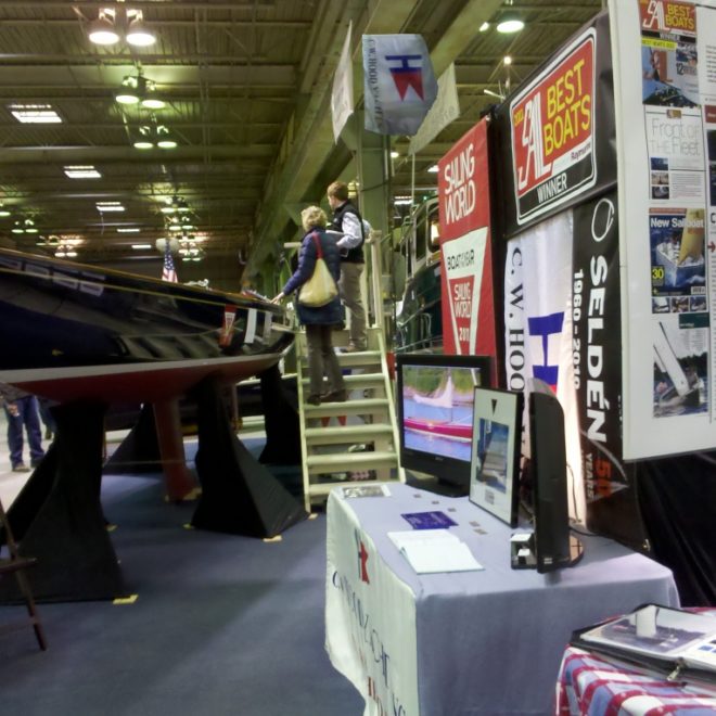 Two guests take in the CW Hood booth and a gorgeous new daysailer on display..