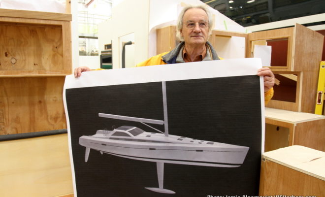 Dr. Stanley Paris holds a rendering of KIWI SPIRIT, the yacht in which he will try to break one of the great sailing records.