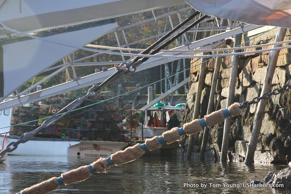 The view under a schooner's bow, as a lobsterboat unloads its traps.