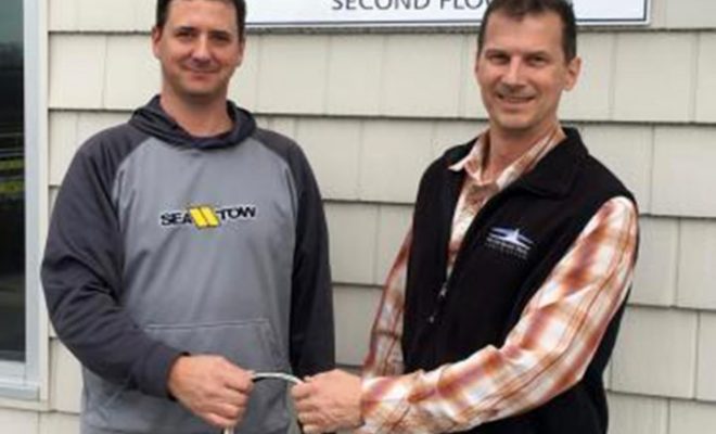 Sea Tow Portland/Midcoast co-owner Capt. Matt Wilder (left) provides a Sea Tow membership bag to MITA‚Äôs Exec Director Doug Welch