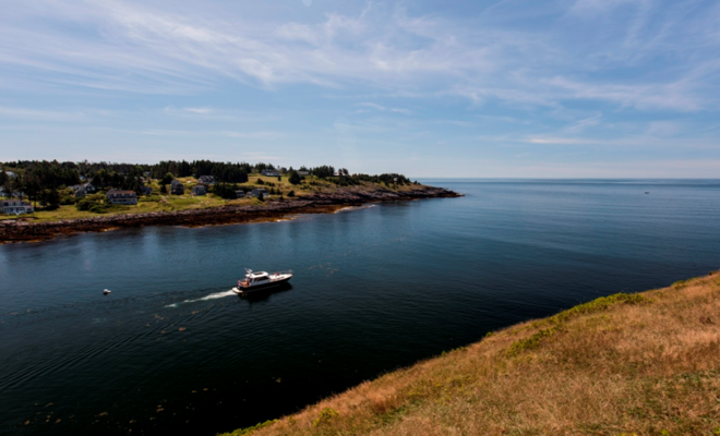 A Hunt 44 powers out of the harbor at Monhegan Island, Maine.