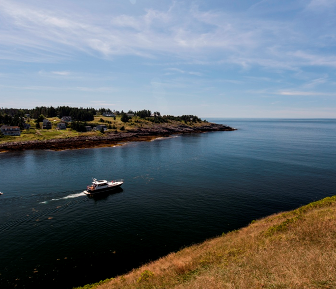 A Hunt 44 powers out of the harbor at Monhegan Island, Maine.