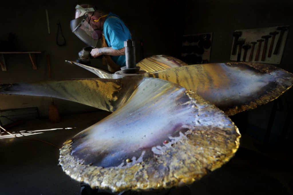 Propeller technician, Steve Saraiva, grinds a propeller he is repairing from a Gloucester fishing boat