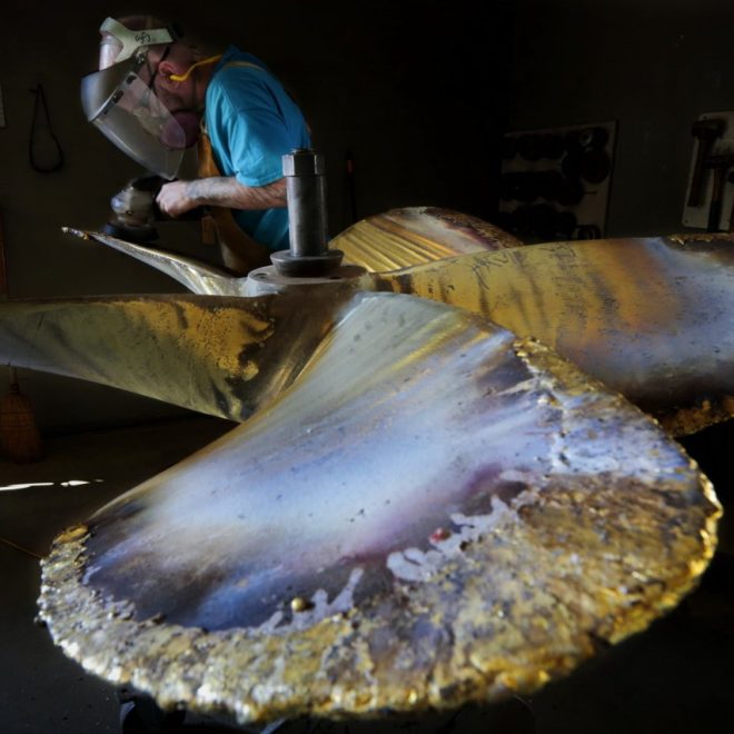 Propeller technician, Steve Saraiva, grinds a propeller he is repairing from a Gloucester fishing boat