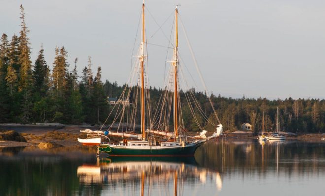 A beautiful schooner, fine as a ship in a bottle, anchored at daybreak.