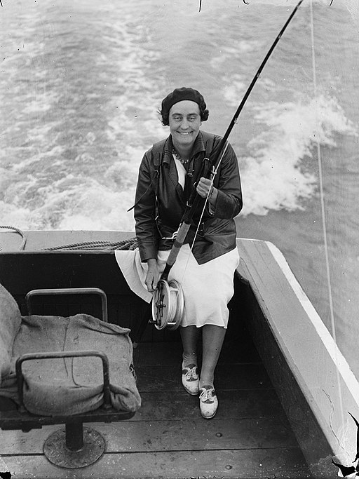 Auckland Museum, CC BY 4.0 <https://creativecommons.org/licenses/by/4.0>, High-angle_view_of_a_woman_seated_in_a_boat_with_a_fishing_rod_AM_78906-1 via Wikimedia Commons