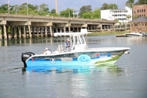 Suzuki Marine Executive Vice President Sales & Service Gus Blakely at the helm of the boat as it arrives at ABC, accompanied by Suzuki Marine President Nobuo Suyama