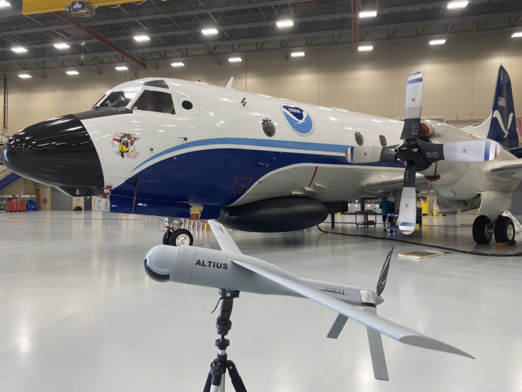 Altius demonstration model with Hurricane Hunter, NOAA WP-3D Orion “Miss Piggy,” at NOAA’s Aircraft Operations Center in Lakeland, FL during the second UAS flight test window on May 25, 2022. Photo Credit: NOAA/AOC Altius demonstration model with Hurricane Hunter, NOAA WP-3D Orion “Miss Piggy,” at NOAA’s Aircraft Operations Center in Lakeland, FL during the second UAS flight test window on May 25, 2022. Photo Credit: NOAA/AOC