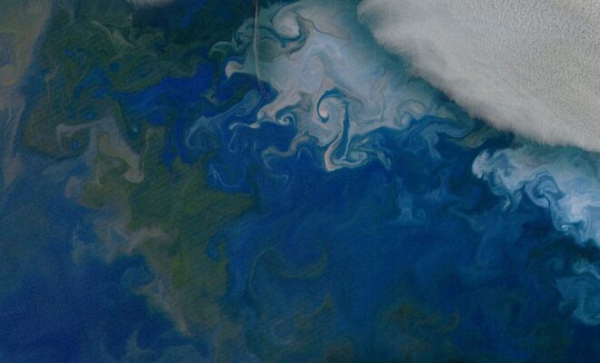 Phytoplankton blooms in the Barents Sea, shown in natural color from NASA's Aqua satellite on July 10, 2014. The solid white area in the top right corner is cloud cover. Credit: NASA's Earth Observatory.