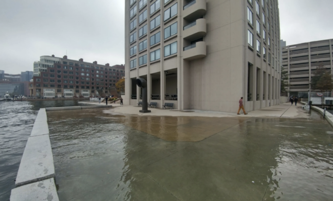 High tide flooding pushes water onto a walkway along the Boston waterfront near India Wharf in 2016. (Image credit: Courtesy of MyCoast.org)