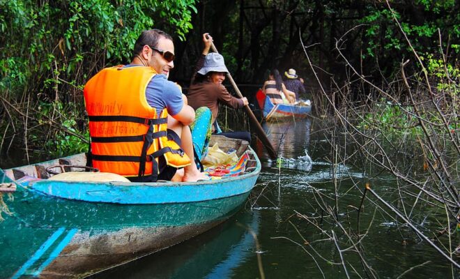 People riding on boat on body of water, floating, forest, floating forest |
