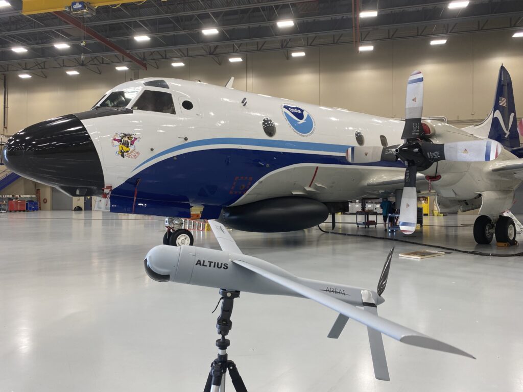 The Altius-600 uncrewed aircraft system demonstration model appears with Hurricane Hunter NOAA WP-3D Orion, known as “Miss Piggy,” at NOAA’s Aircraft Operations Center in Lakeland, Florida, during an uncrewed aircraft system flight test on May 25, 2022. The Altius was recognized by the 2024 Guinness World Records book for the longest endurance flight inside a tropical cyclone by an uncrewed aircraft. (Image credit: NOAA/Aircraft Operations Center)