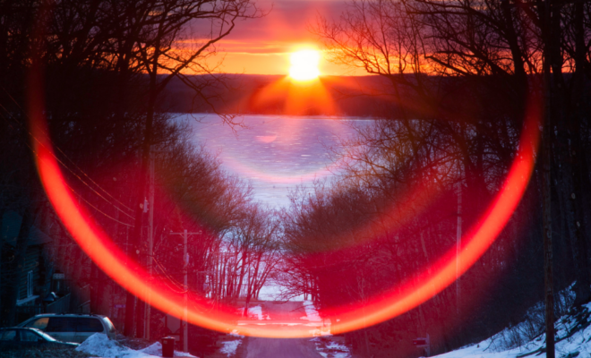 Sunset on a road with frozen lake in front. Image from Canva.com