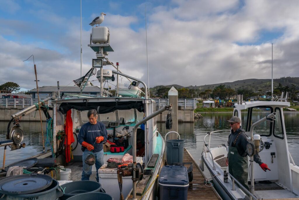 Commercial fishermen George Jue, left, and Dan St. Clair work at Pillar Point Harbor in Half Moon Bay.