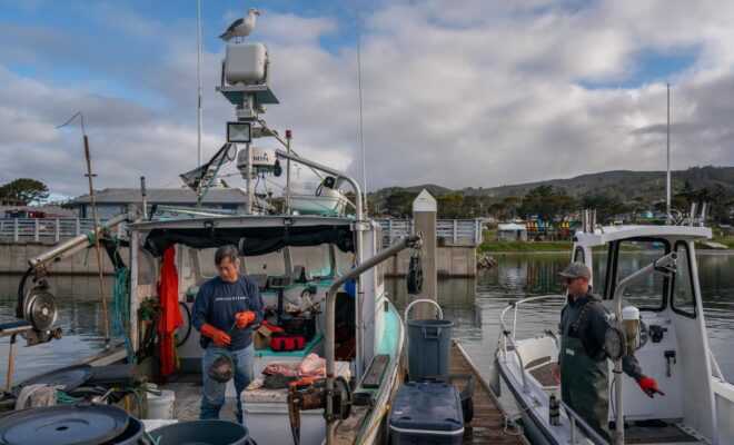 Commercial fishermen George Jue, left, and Dan St. Clair work at Pillar Point Harbor in Half Moon Bay.