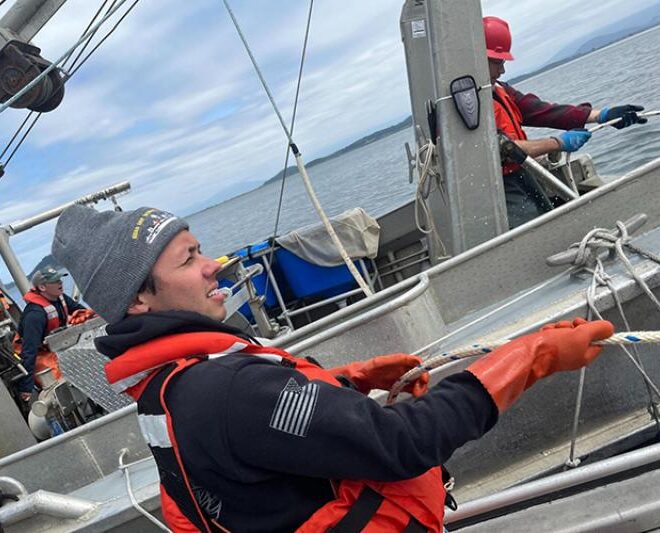 Image Credits: Former NOAA veteran intern Garret Engelke pulls in a surface trawling net on the Puget Sound with NOAA scientists.