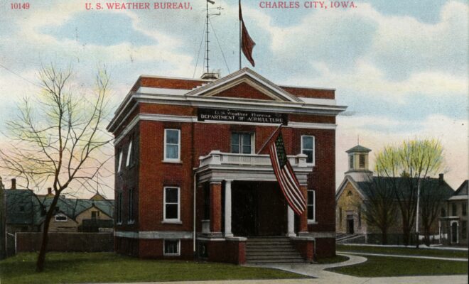 Image Credits: Postcard of the U.S. Weather Bureau Building at Charles City, Iowa. c. 1900. Note the Weather Forecast Flag system flags flown on the flag pole mounted on the roof. They appear to be the blue flag with a black pennant above, indicating a forecast of higher temperatures and rain. (Image credit: Courtesy of Steve Doty, NOAA NCDC (ret.))