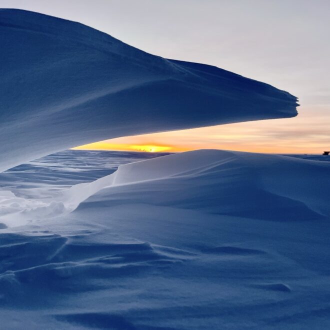Image Credits: MARCH 20, 2025: At NOAA's South Pole Atmospheric Baseline Observatory, a wave of snow frames Dark Sector telescopes, giving a final glimpse of sunlight before six months of darkness. (Image credit: Ian Crocker/NOAA)