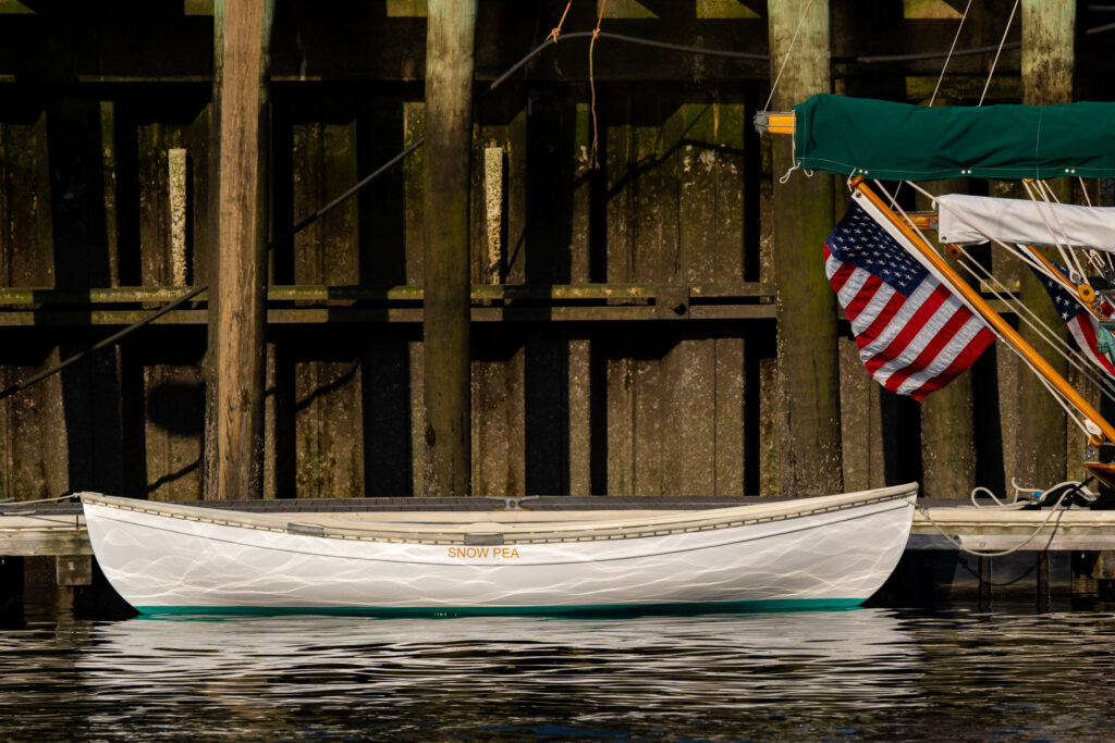 A white pea pod dinghy at the dock
