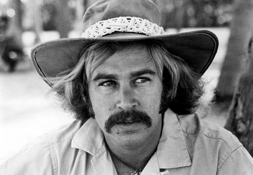 Jimmy Buffett wearing a hat, black and white portrait.