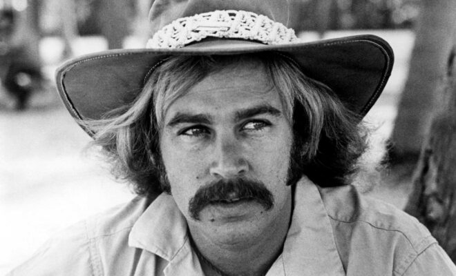 Jimmy Buffett wearing a hat, black and white portrait.