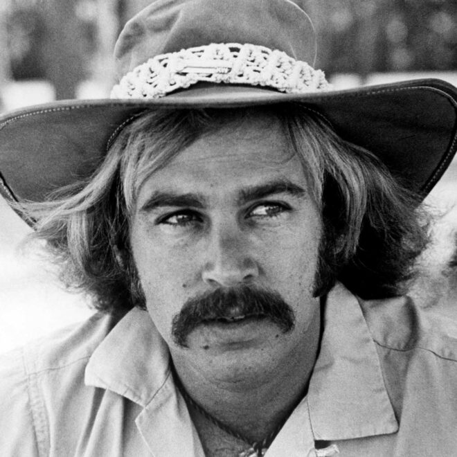 Jimmy Buffett wearing a hat, black and white portrait.